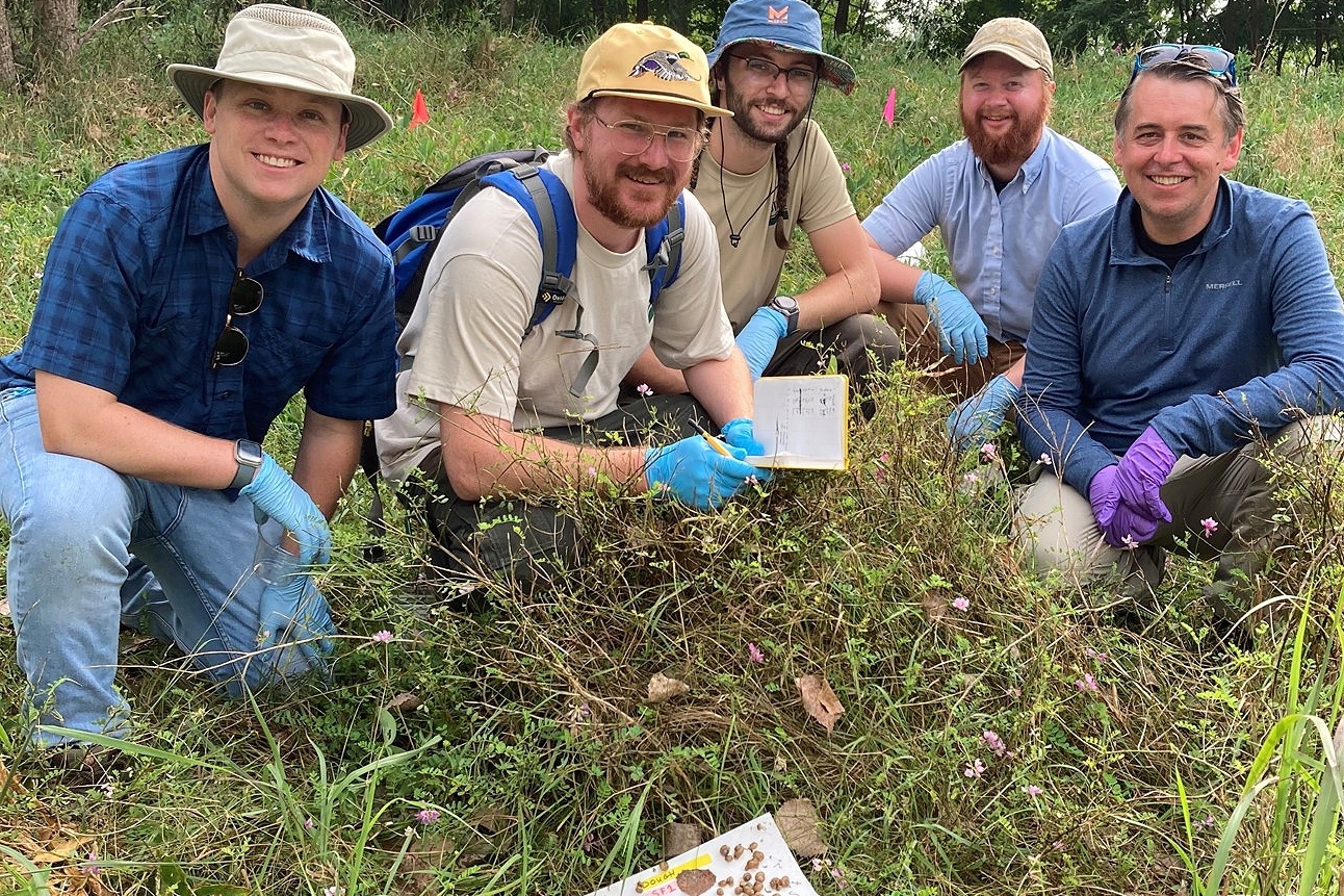 Five Scientists recording recorded the number of snails on paperboard traps.