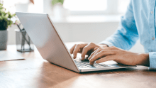 Hands of contemporary office worker over laptop keypad