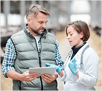 An attending veterinarian talking with a licensee